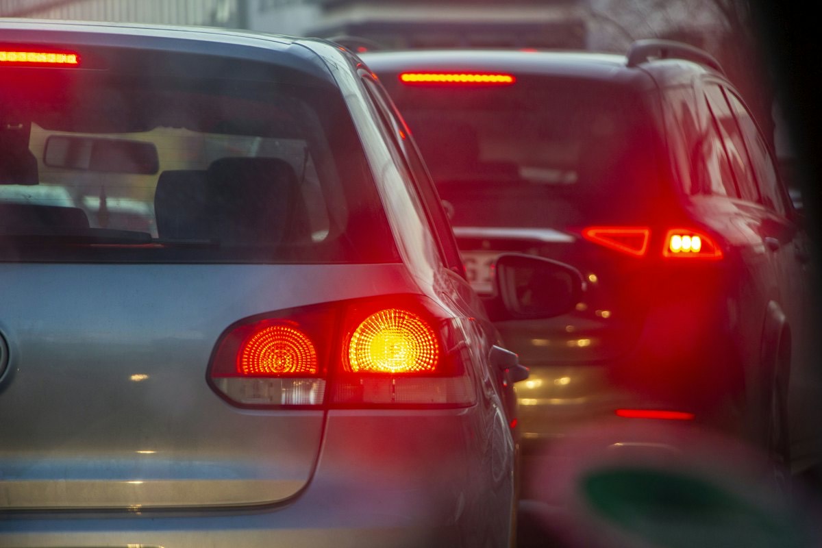 Brake lights glowing on a line of cars in slow traffic